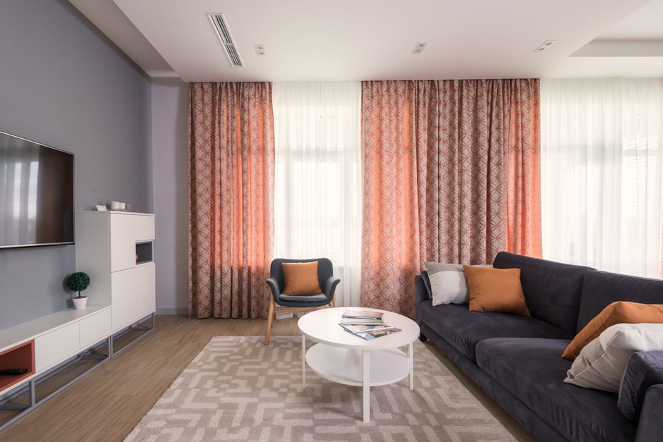Lichtdoorlatende oranje gordijnen in trendy woonkamer. Lichtdoorlatende oranje gordijnen in trendy woonkamer.